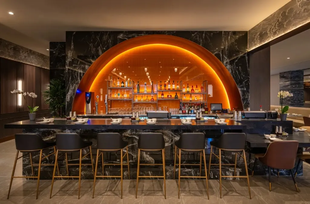 The bar, with an orange arch and marble stools