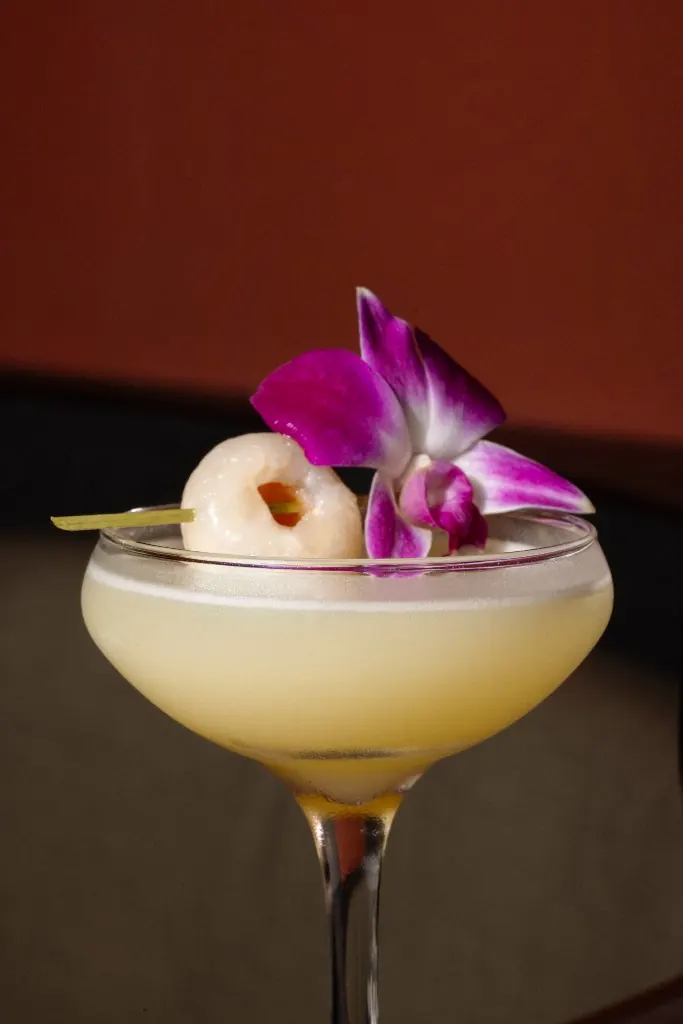 A lychee martini garnished with an orchid